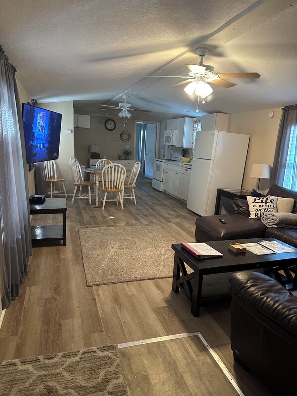 A spacious living area with a dining table, chairs, a sofa, and a television. - “Divers Inn” on The Rainbow River (Dunnellon)