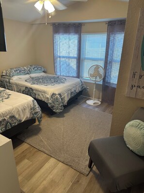 A bedroom with two beds, a ceiling fan, and a window with blinds. - “Divers Inn” on The Rainbow River (Dunnellon)