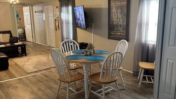 A dining area with a table, chairs, and a ceiling fan.