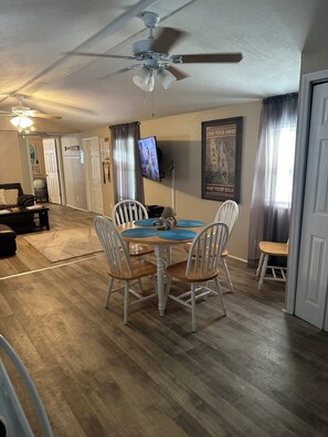 A dining area with a table, chairs, and a ceiling fan. - “Divers Inn” on The Rainbow River (Dunnellon)