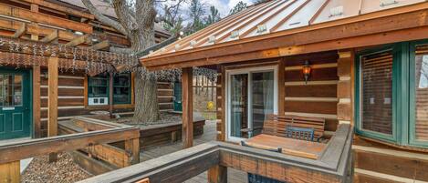 A log cabin-style building with a wooden deck, a covered seating area, and a sign reading 'MASTER SUITE'.
