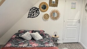 Un dormitorio con cama, una puerta y adornos en la pared.