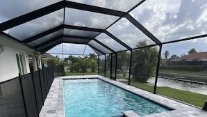 En pool med tak, varifrån man har utsikt över ett bostadsområde och en flod.