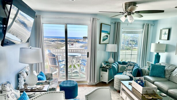 A living room with a large sliding glass door leading to a balcony, a ceiling fan, and a view of a snowy landscape. - Amazing Unobstructed Beach Views! 🏖️Beautifully equipped with nice furnishings! (Gulf Shores)