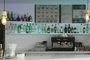 A bar area with a coffee menu, a selection of liquor bottles, and a coffee machine.