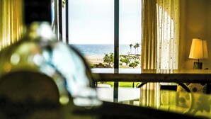 A room with a view of the ocean, a lamp on a bedside table, and a window with curtains. - Beautiful luxuries affordable, quiet ocean view one bedroom home away from away (San Jose del Cabo)