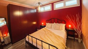 A bedroom with a bed, nightstands, a wardrobe, and a ceiling light fixture. - WellHome   "Barbera" Apartment (ASTI)