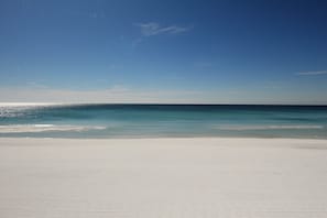 Ein Strand mit blauem Himmel und ruhiger See.