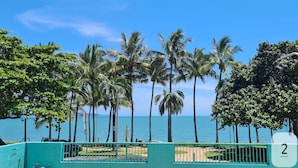 A coastal view with palm trees and a clear blue sky. - Emthree Seaside Apartments (North Ward)