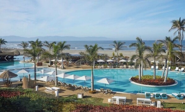 Relax by the pool surrounded by palm trees and enjoy stunning ocean views.