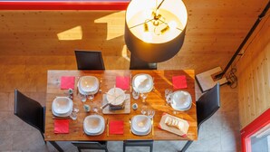 Une table à manger dressée pour quatre personnes, avec assiettes, verres et couverts.