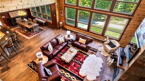 A spacious living area with a large window, a fireplace, and a cozy seating arrangement.