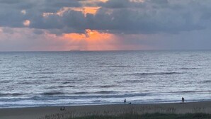 Una playa con aguas tranquilas y un cielo al atardecer.