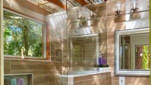 Une salle de bain moderne avec une douche à parois de verre, un grand miroir et un meuble-lavabo.