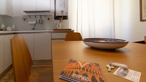 A dining area with a wooden table, a bowl, a book titled "Venezia City Map," and a keychain. - Apartment Campaniel Veneziacentopercento (Venezia)