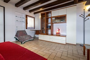 Una stanza con un letto, una sedia, una scrivania e una libreria a muro.