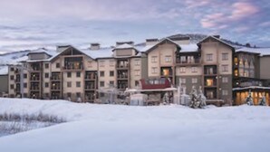 A multi-story hotel with a snow-covered landscape in the background.