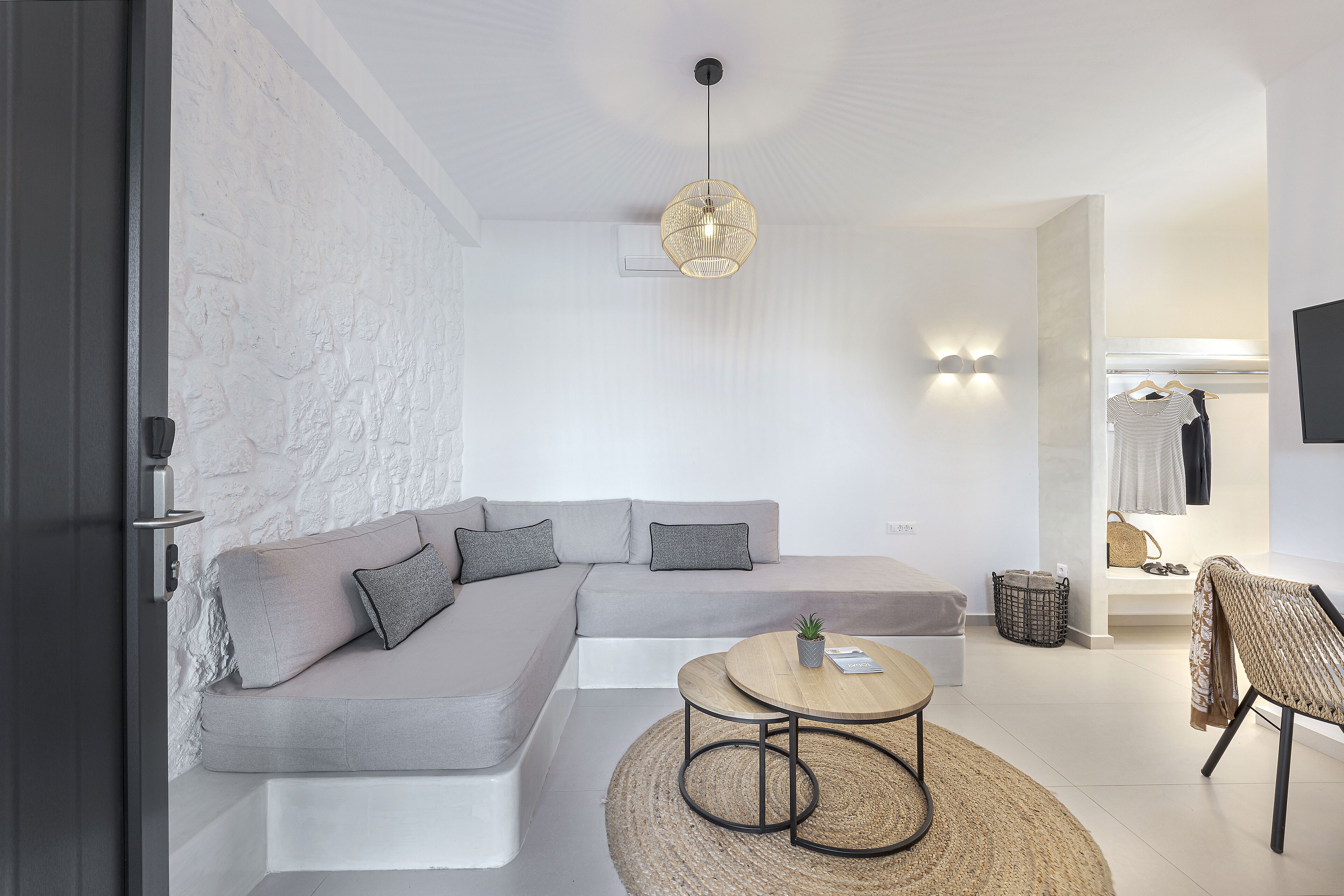 Una sala de estar moderna con un sofá seccional, una mesa de centro redonda y una lámpara colgante.