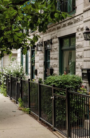Stunning residential building with a stone facade and lush greenery.