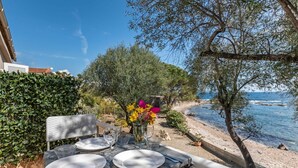A table set for dining with a view of the sea and a tree in the background. - Beautiful apartment in villa for 3 people with WIFI, A/C, TV and terrace (Solenzara)