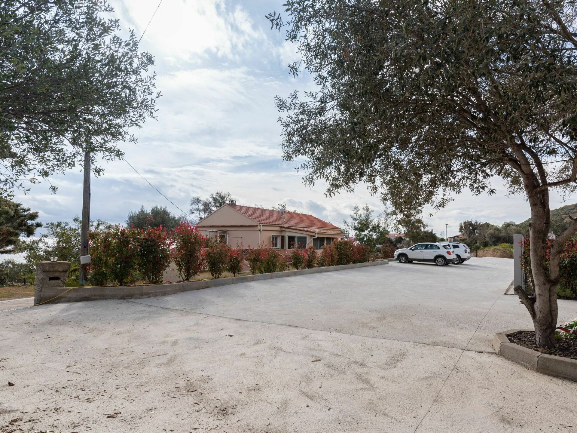 Un quartier résidentiel avec une maison, une allée pavée et une voiture garée.