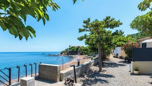 A coastal property with a concrete staircase leading to a pebble beach, a metal railing, and a clear view of the sea. - Cosy apartment in villa for 4 people with A/C, WIFI and TV (Solenzara)