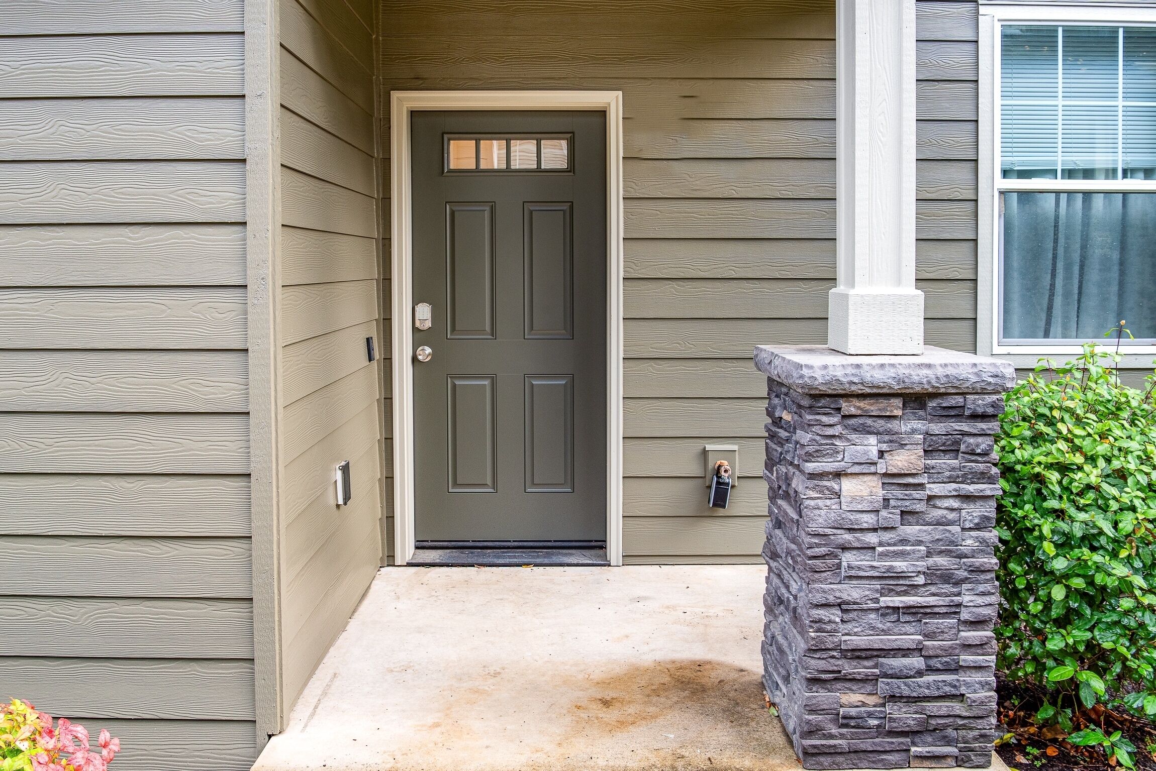 A front door with a stone base, a mailbox, and a small step leading to the entrance.