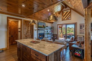 A spacious kitchen with a large island, wooden cabinetry, and pendant lighting.