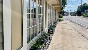 A building with large windows and a row of flower boxes along the sidewalk.