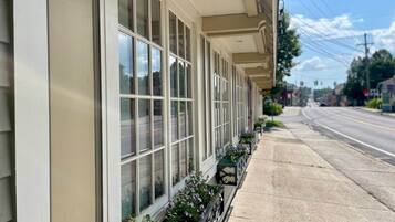 A building with large windows and a row of flower boxes along the sidewalk.