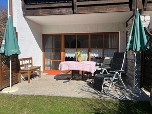 A patio with a table, chairs, and umbrellas. - Vacation apartment Falkenstein for 2 persons with terrace, 45 sqm, eat-in kitchen (Inzell)