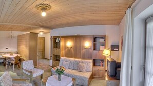 A cozy living room with a wooden ceiling, a sofa, a coffee table, and a television. - Vacation apartment 4 for 2 persons, 1 bedroom, upper floor, balcony, 53 m² (Inzell)
