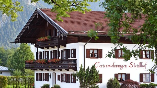 A traditional Alpine-style building with a balcony, wooden shutters, and a sign reading "Ferienwohnungen Steidlhof". - Vacation apartment 4 for 2 persons, 1 bedroom, upper floor, balcony, 53 m² (Inzell)