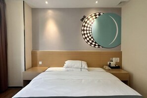 A hotel room with a bed, a bedside table, a wall-mounted clock, and a wall art piece. - City Comfort Inn (Zhuhai Qinglv Middle Road) (Zhuhai)