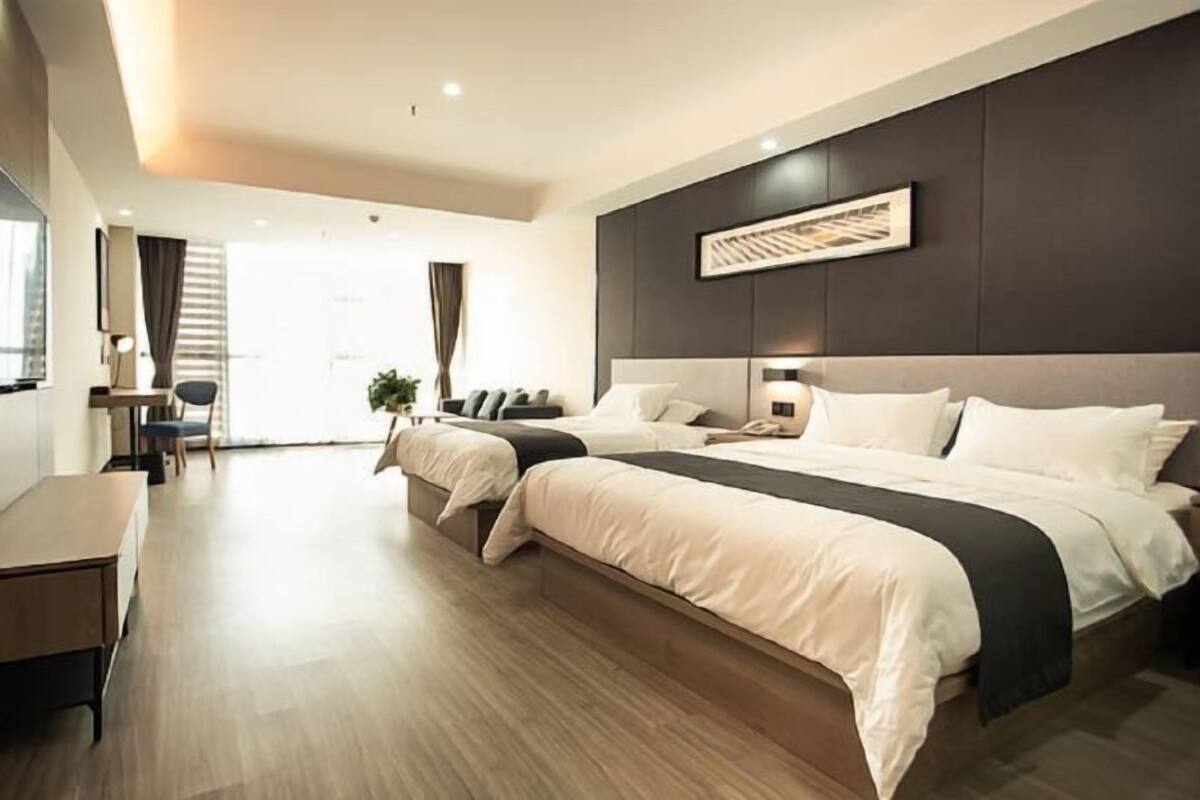 Habitación de hotel moderna con una cama grande, un escritorio y vistas al exterior.