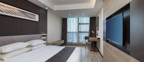 Una habitación de hotel moderna con una cama grande, un escritorio y una televisión.