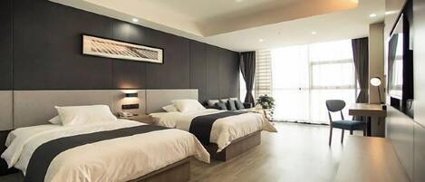 A modern hotel room with two beds, a desk, and a large window.