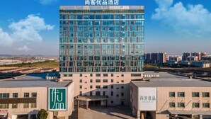 A modern hotel with a glass facade, a flat roof, and a sign indicating it is a customer-friendly establishment. - Shankee Tea Style Hotel (Danyang Economic Development Zone) (Danyang)