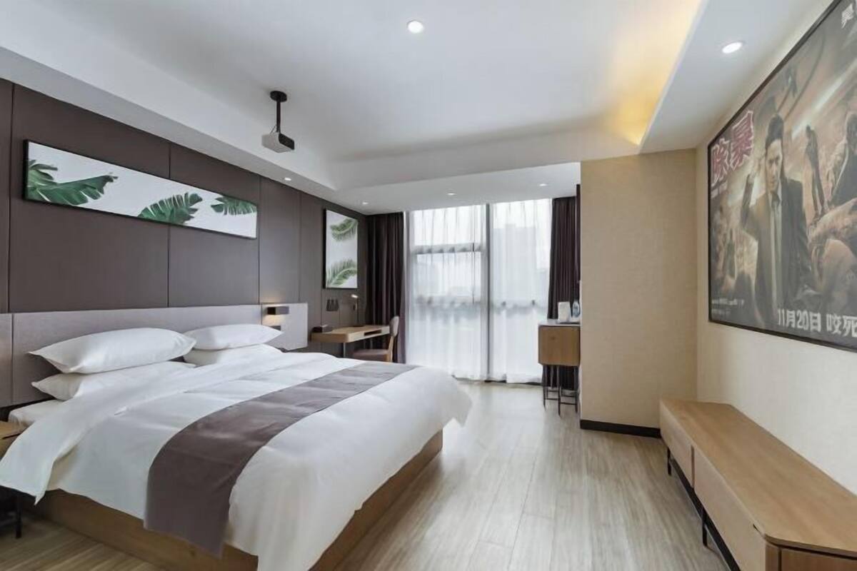 Una habitación de hotel moderna con una cama grande, un escritorio y una zona de estar.
