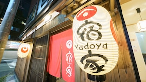 A restaurant with traditional Japanese decor, including hanging lanterns with the restaurant's name and logo. - Yadoya Fukurou (Tokyo)
