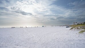 A wide sandy beach with a pier in the distance and a building on the right. - Tropical 2-Bdr Condo with Pool on Siesta Key Beach (Sarasota)