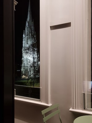 A window with a view of a lit-up building at night. - Bell Hill Apartments (Dunedin)