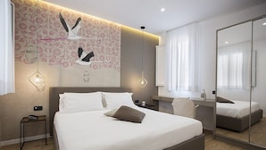 A modern hotel room with a large bed, a bedside table, a desk, and a mirror. - Appartamento Anice A: A welcoming apartment situated in a central location, at a short distance from the main tourist attractions of the city, with Free WI-FI. (Trapani)