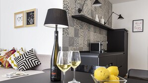 A modern kitchen with a black countertop, two wine glasses, a bottle of wine, and a bowl of lemons. - Appartamento Anice A: A welcoming apartment situated in a central location, at a short distance from the main tourist attractions of the city, with Free WI-FI. (Trapani)