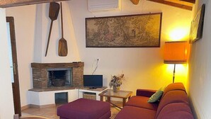 A living room with a fireplace, a sofa, a television, and a lamp.