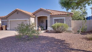 A residential house with a garage, a covered entryway, and a small garden area with gravel and plants. - Family Home w/ Community Perks in Peoria (Peoria)