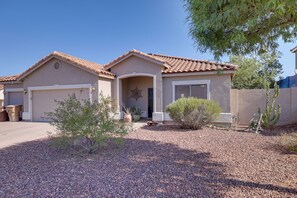 A residential house with a garage, a covered entryway, and a small garden area with gravel and plants. - Family Home w/ Community Perks in Peoria (Peoria)