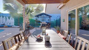 An outdoor patio with a table, chairs, a grill, and potted plants. - Family Home w/ Community Perks in Peoria (Peoria)