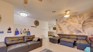 A modern living room with a leather sofa, a patterned rug, and a ceiling fan. - Family Home w/ Community Perks in Peoria (Peoria)
