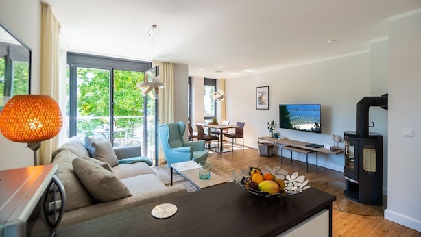 Uma sala de estar moderna com sofá, mesa de centro, TV e lareira.